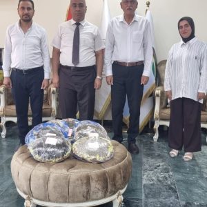طالبة ماجستير في كلية الزراعة تهدي أقراصاً من بذور زهرة الشمس الناتجة عن بحثها إلى عميد الكلية.